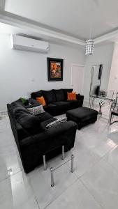 a living room with a black couch and chairs at Elegant Oasis by the Sea in Saint Annʼs Bay