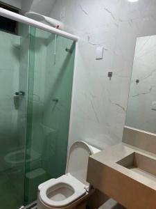 a bathroom with a toilet and a glass shower at Loft Solaris Apart Hotel - Suíte - Apt. N.105 in João Câmara