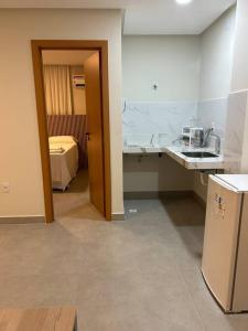 Zimmer mit einer Küche mit einem Waschbecken und einem Bett in der Unterkunft Loft Solaris Apart Hotel - Suíte - Apt. N.105 in João Câmara