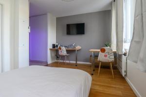 1 dormitorio con 1 cama, mesa y sillas en Chartres Charmant Studio Meublé en Chartres