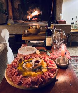a table with a plate of food and a fireplace at Relais Valpolicella B&B in Marano di Valpolicella