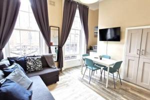 - un salon avec un canapé et une table avec des chaises dans l'établissement Great Central Location 1BED APT Off OConnell ST, à Dublin