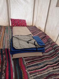 una pila de ropa sentada en una cama en una tienda en flamingo camp en Dār as Salām