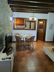 cocina y comedor con mesa y TV en Apartamento Serrano Gran Vía Centro, en Granada