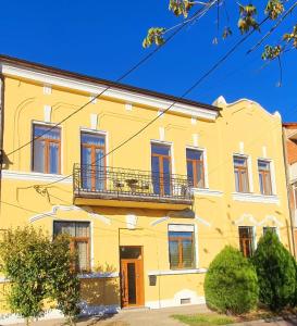 Maison jaune avec balcon dans une rue dans l'établissement ORI ELEGANCE Malul Muresului, à Arad