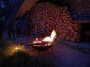 un fuego en una parrilla con un montón de troncos en Kalinówka Kościelisko, en Kościelisko
