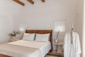 a bedroom with a bed with white sheets and white pillows at Trulli Mest'Andrea alle lame in Noci