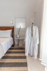 a bedroom with a bed and a robe on a rack at Trulli Mest'Andrea alle lame in Noci