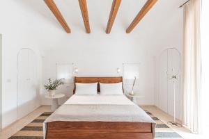um quarto com uma cama grande e uma cabeceira em madeira em Trulli Mest'Andrea alle lame em Noci