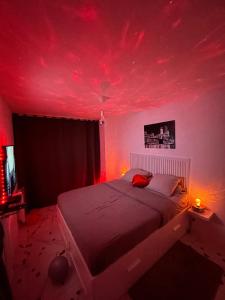 - une chambre avec un lit et un plafond rouge dans l'établissement Jennah Spa, à Montereau-faut-Yonne