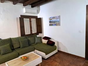 Apartamento Serrano Gran Vía Centro في غرناطة: غرفة معيشة مع أريكة خضراء وطاولة