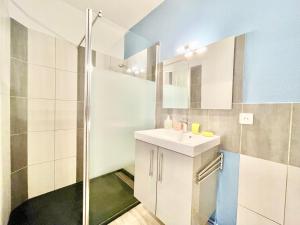 La salle de bains est pourvue d'un lavabo et d'une douche. dans l'établissement A L'ABORDAGE APPART - Lorient centre - Au calme, à Lorient