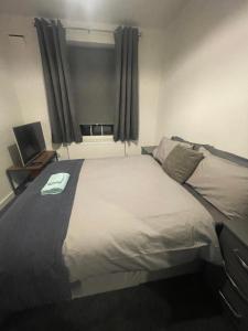 a bedroom with a large bed with a window at Super Streatham Room in London