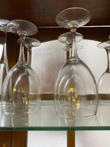 three glass wine glasses sitting on a glass table at Confortable apartamento- Cotuí in Cotuí