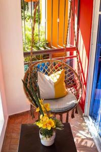 eine Hollywoodschaukel mit einem Stuhl und einer Vase aus Blumen in der Unterkunft Confortable apartamento- Cotuí in Cotuí