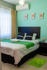 a bedroom with a large bed with blue walls at Confortable apartamento- Cotuí in Cotuí