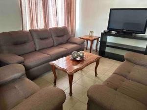 sala de estar con sofá y TV en Casa Coy, en Ciudad Valles
