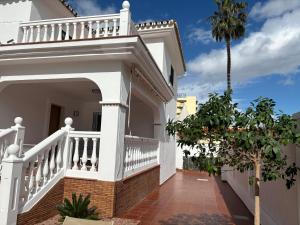 Cette maison blanche dispose d'un balcon et d'un palmier. dans l'établissement Gran villa en Torremolinos, à Torremolinos
