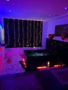 a living room with a tub in a purple room at Jennah Spa in Montereau-Fault-Yonne