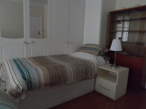 una camera con letto e lampada su comodino di Compton Guest House a Londra