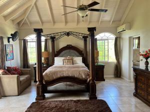 a bedroom with a bed and a ceiling fan at Retreat Guest House in Falmouth