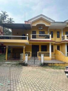 a large yellow house with a driveway in front of it at Cool viva Goa villa near beach in Colva