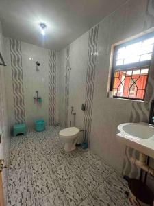 a bathroom with a toilet and a sink and a window at Cool viva Goa villa near beach in Colva