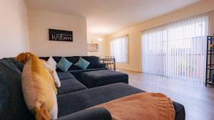 Long Beach Cozy Remodled Home في لونغ بيتش: غرفة معيشة مع أريكة زرقاء ونافذة كبيرة