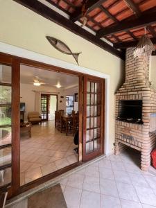 a living room with a fireplace and a dining room at Paúba Beach House in São Sebastião