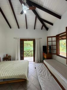 1 dormitorio con 2 camas y ventana en Paúba Beach House, en São Sebastião