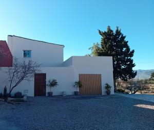 a white house with two doors and a tree at Casa nuestro sueño in Partaloa