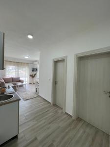 a kitchen and living room with white walls and wooden floors at Summer Dreams in Bar