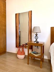 1 dormitorio con mesa y espejo en Casa Berty 2 en Ensenada