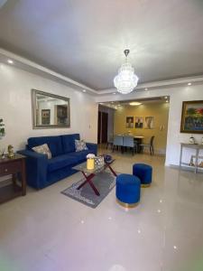 a living room with a blue couch and a table at Confortable apartamento- Cotuí in Cotuí
