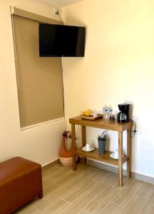 um quarto com uma mesa e uma televisão na parede em Casa Berty 2 em Ensenada