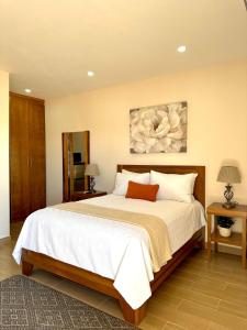 1 dormitorio con 1 cama grande con sábanas blancas en Casa Berty 2 en Ensenada