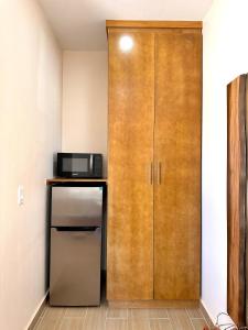 a kitchen with a refrigerator and a wooden door at Casa Berty 2 in Ensenada