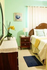 Un dormitorio con 2 camas y una mesa con una planta en Confortable apartamento- Cotuí en Cotuí