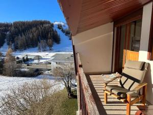 una sedia a dondolo seduta su un portico con vista sulle montagne di Valberg 3 pièces au pied des pistes a Péone