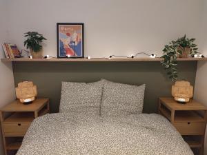 a bedroom with a bed with two nightstands and two plants at La Glycine, Appartement d'architecte avec vue sur jardin in La Courneuve
