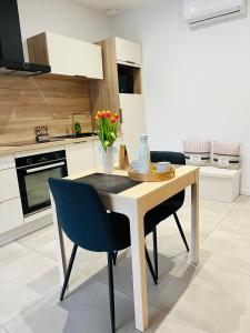 cocina con mesa de madera y 2 sillas en Appartement centre de Roanne 38m2 en Roanne