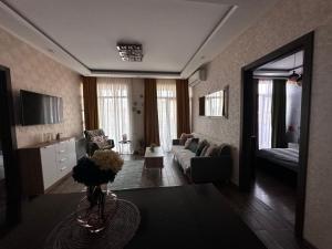 ein Wohnzimmer mit einem Sofa und einem Tisch in der Unterkunft AnnaMari in Tbilisi City