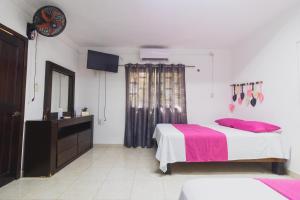 a bedroom with a bed and a dresser and a mirror at Zayali Bacalar - Guest House in Bacalar