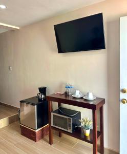 Zimmer mit einer Mikrowelle und einem Tisch mit einem TV in der Unterkunft Casa Berty 4 in Ensenada