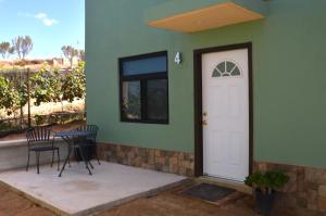 eine Veranda mit einem Tisch und einer weißen Tür in der Unterkunft Casa Berty 4 in Ensenada