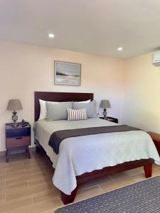 ein Schlafzimmer mit einem großen Bett und zwei Nachttischen in der Unterkunft Casa Berty 4 in Ensenada