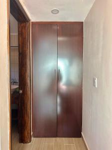 eine große Holztür in einem Zimmer mit Bad in der Unterkunft Casa Berty 4 in Ensenada