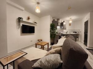 ein Wohnzimmer mit einem Sofa und einem Tisch in der Unterkunft ApartHotel Flat 1 - 10 min to centre by Property Promise in Cardiff