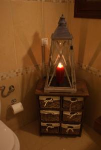 a candle in a lantern on a table in a bathroom at Αρχοντικό Ειρήνη - 6 Metsovo in Metsovo