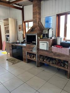 a kitchen with a counter with a microwave and appliances at Casa aconchegante ótima para rlx in Barra Velha